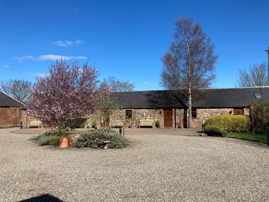 The gravel courtyard and converted stone stable apartments at Perthshire Courtyard