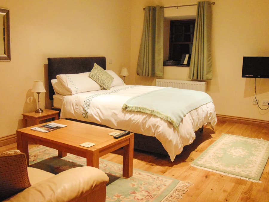 Spacious bedroom with seating area in a Perthshire Courtyard apartment